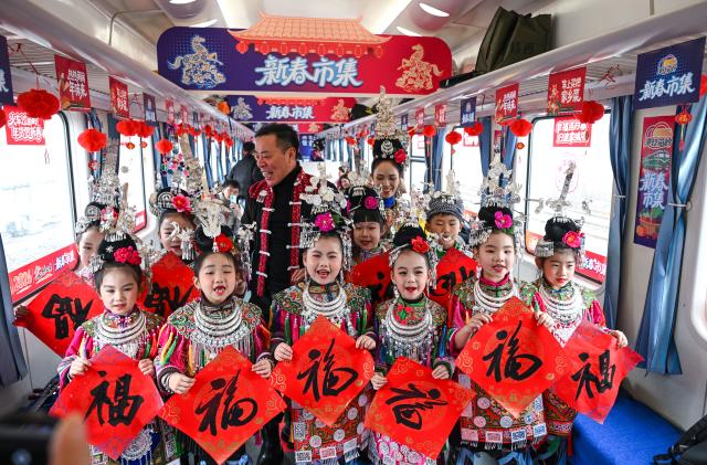 (260209) -- KAILI, Feb. 9, 2026 (Xinhua) -- Children send New Year greetings on the train No. 5640 in southwest China's Guizhou Province on Feb. 8, 2026. The train No. 5640 runs in Guizhou Province between Yuping Dong Autonomous County of Tongren City and provincial capital Guiyang City. It connects more than 100 ethnic minority villages along the route and makes travel more convenient for the villagers.
   A New Year market has been introduced on the train No. 5640 upon the upcoming Chinese New Year, during which fresh agricultural products and folk customs were displayed for passengers along the way. (Xinhua/Yang Wenbin)
