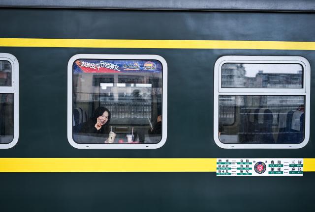 (260209) -- KAILI, Feb. 9, 2026 (Xinhua) -- A passenger is pictured on the train No. 5640 in southwest China's Guizhou Province on Feb. 8, 2026. The train No. 5640 runs in Guizhou Province between Yuping Dong Autonomous County of Tongren City and provincial capital Guiyang City. It connects more than 100 ethnic minority villages along the route and makes travel more convenient for the villagers.
   A New Year market has been introduced on the train No. 5640 upon the upcoming Chinese New Year, during which fresh agricultural products and folk customs were displayed for passengers along the way. (Xinhua/Yang Wenbin)