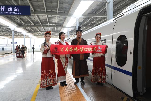 (260209) -- LANZHOU, Feb. 9, 2026 (Xinhua) -- Museum staff members welcome passengers at Lanzhou West Railway Station in Lanzhou, northwest China's Gansu Province, Feb. 9, 2026. As part of the mobile museum on the high-speed railway program, the train G848, carrying cultural relics interpreters, departed from Lanzhou West Railway Station heading to Guangzhou South Railway Station on Monday.
   Nine of China's national first-grade museums in Gansu, including the Dunhuang Academy and Gansu Provincial Museum, have brought the cultural heritage of Gansu onto the train, allowing passengers to touch history and get to know traditional custom during the Spring Festival travel rush. (Xinhua/Zhang Zhimin)
