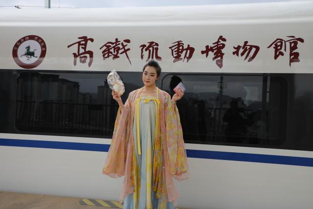 (260209) -- LANZHOU, Feb. 9, 2026 (Xinhua) -- A museum staff member displays cultural and creative products at a railway station in Qin'an County of Tianshui City, northwest China's Gansu Province, Feb. 9, 2026. As part of the mobile museum on the high-speed railway program, the train G848, carrying cultural relics interpreters, departed from Lanzhou West Railway Station heading to Guangzhou South Railway Station on Monday.
   Nine of China's national first-grade museums in Gansu, including the Dunhuang Academy and Gansu Provincial Museum, have brought the cultural heritage of Gansu onto the train, allowing passengers to touch history and get to know traditional custom during the Spring Festival travel rush. (Xinhua/Zhang Zhimin)