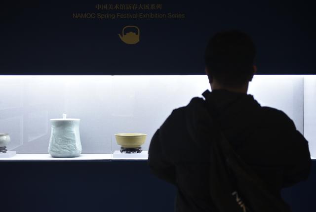 (260209) -- BEIJING, Feb. 9, 2026 (Xinhua) -- A visitor views exhibits at the National Art Museum of China in Beijing, capital of China, Feb. 9, 2026. The opening ceremony of the Spring Festival Exhibition Series of National Art Museum of China (NAMOC) was held here on Monday. The series includes five exhibitions, covering various art forms such as Chinese painting, oil painting, printmaking, sculpture, etc. (Xinhua/Lu Peng)