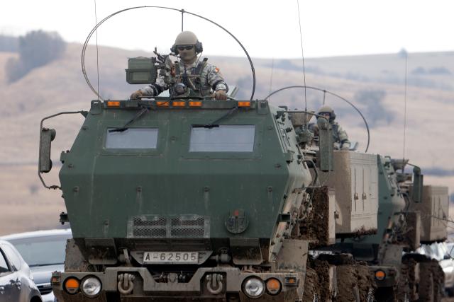 (260209) -- CINCU, Feb. 9, 2026 (Xinhua) -- A Romanian soldier is seen on top of a vehicle carrying a High Mobility Artillery Rocket System launcher during the Dynamic Front 26 military exercise at the Cincu Training Area in Cincu, Brasov County, Romania, on Feb. 9, 2026. (Photo by Cristian Cristel/Xinhua)