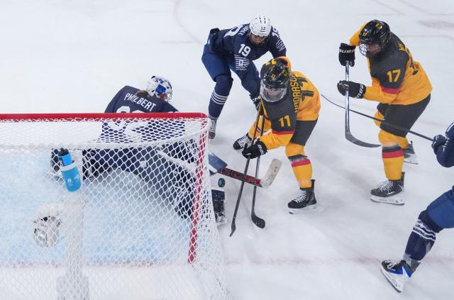 (260209) -- MILAN, Feb. 9, 2026 (Xinhua) -- Goalkeeper Alice Philbert (1st L) of France defends during the ice hockey women's preliminary round group B match between Germany and France at the Milan-Cortina 2026 Olympic Winter Games in Milan, Italy, Feb. 9, 2026. (Xinhua/Wang Kaiyan)