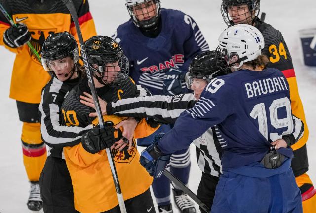 (260209) -- MILAN, Feb. 9, 2026 (Xinhua) -- Referees stops Daria Gleissner (2nd L) of Germany and Lore Baudrit (1st R) of France fighting during the ice hockey women's preliminary round group B match between Germany and France at the Milan-Cortina 2026 Olympic Winter Games in Milan, Italy, Feb. 9, 2026. (Xinhua/Sun Fei)