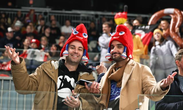 (260209) -- MILAN, Feb. 9, 2026 (Xinhua) -- Spectators pose during the ice hockey women's preliminary round group B match between Germany and France at the Milan-Cortina 2026 Olympic Winter Games in Milan, Italy, Feb. 9, 2026. (Xinhua/Wang Kaiyan)