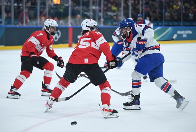 (260209) -- MILAN, Feb. 9, 2026 (Xinhua) -- Alina Muller (C) of Switzerland vies with Cayla Barnes of the United States during the ice hockey women's preliminary round group A match between Switzerland and the United States at the Milan-Cortina 2026 Olympic Winter Games in Milan, Italy, Feb. 9, 2026. (Xinhua/Zhang Haofu)