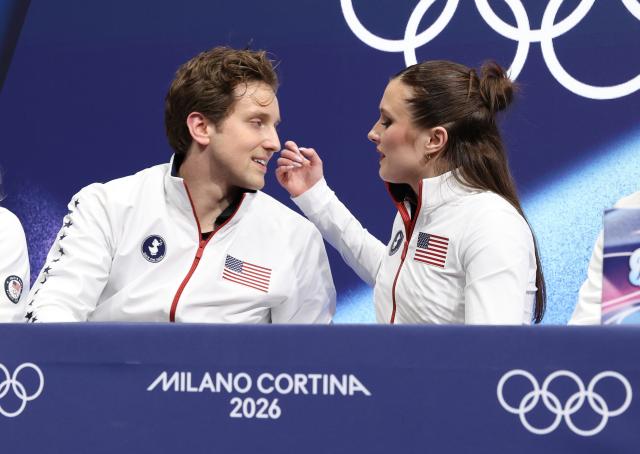 (260210) -- MILAN, Feb. 10, 2026 (Xinhua) -- Christina Carreira (R)/Anthony Ponomarenko of the United States react after performing during the rhythm dance of figure skating ice dance competition at the Milan-Cortina 2026 Olympic Winter Games in Milan, Italy, Feb. 9, 2026. (Xinhua/Chen Yichen)
