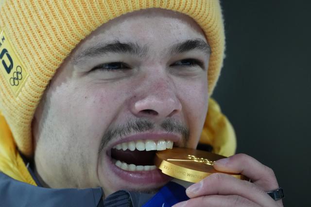 (260210) -- PREDAZZO, Feb. 10, 2026 (Xinhua) -- Gold medallist Philipp Raimund of Germany bites the medal during the awarding ceremony for the Ski Jumping Men's Normal Hill Individual of the 2026 Milan-Cortina Winter Olympics in Predazzo, Italy, Feb. 9, 2026. (Xinhua/Meng Yongmin)