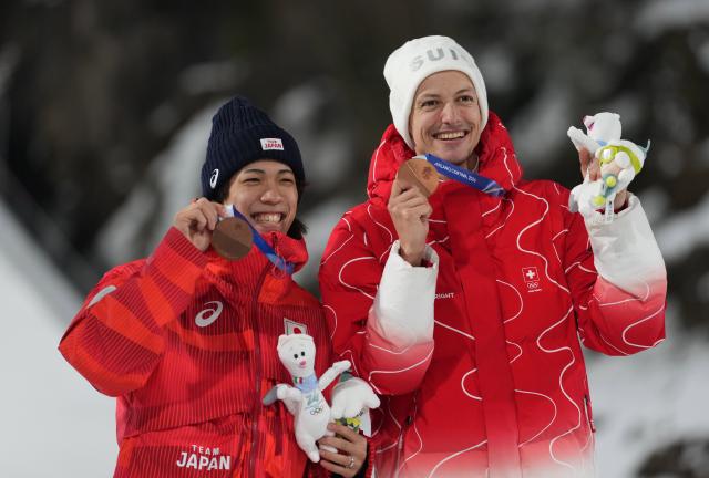 (260210) -- PREDAZZO, Feb. 10, 2026 (Xinhua) -- Bronze medalists Nikaido Ren (L) of Japan and Gregor Deschwanden of Switzerland pose for photos with the medals during the awarding ceremony for the Ski Jumping Men's Normal Hill Individual of the 2026 Milan-Cortina Winter Olympics in Predazzo, Italy, Feb. 9, 2026. (Xinhua/Meng Yongmin)