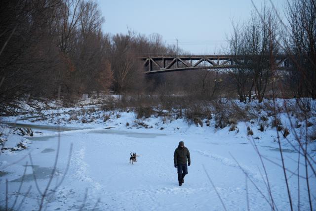 (260210) -- WARSAW, Feb. 10, 2026 (Xinhua) -- A man walks his dog on a frozen river in Warsaw, Poland, on Feb. 9, 2026. (Photo by Jaap Arriens/Xinhua)