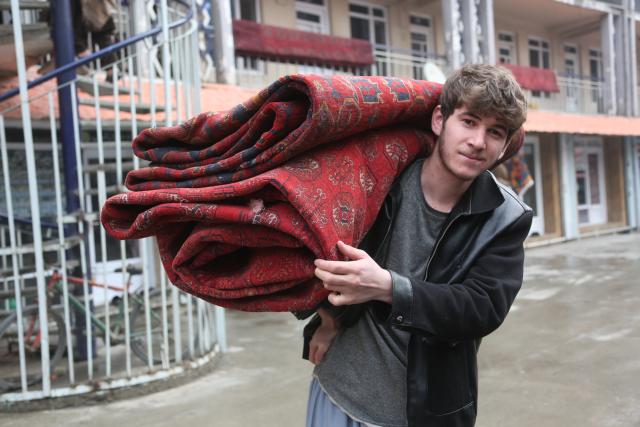 (260210) -- KABUL, Feb. 10, 2026 (Xinhua) -- A man carries handmade carpets in Kabul, the capital of Afghanistan, Feb. 10, 2026. (Photo by Saifurahman Safi/Xinhua)