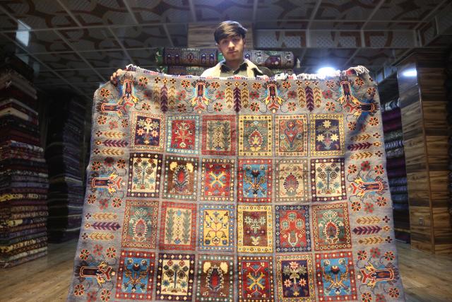 (260210) -- KABUL, Feb. 10, 2026 (Xinhua) -- A man displays a carpet in Kabul, the capital of Afghanistan, Feb. 10, 2026. (Photo by Saifurahman Safi/Xinhua)