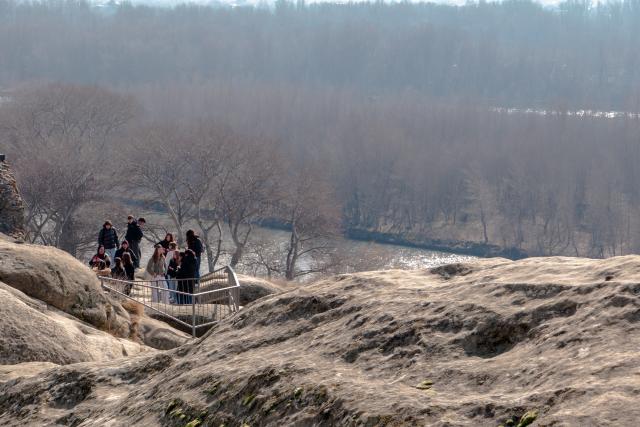 (260210) -- GORI, Feb. 10, 2026 (Xinhua) -- People visit the ruins of the Uplistsikhe rock-hewn city near Gori, Georgia, on Jan. 30, 2026. The Uplistsikhe rock-hewn city ruins is located on a high rocky hill on the bank of the Kura River near Gori in Georgia. It has been on the UNESCO World Heritage Tentative List since 2007. (Xinhua/Chen Junfeng)