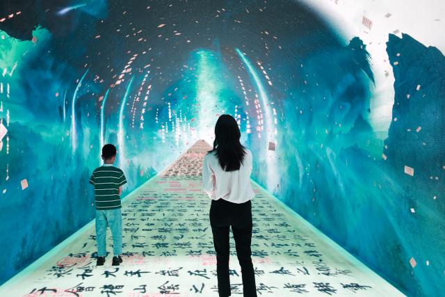 (260210) -- SYDNEY, Feb. 10, 2026 (Xinhua) -- People enjoy an immersive digital experience exhibition with Chinese cultural element at DigiPark Sydney in Sydney, Australia, Feb. 10, 2026. The DigiPark Sydney launched an immersive digital experience exhibition on traditional Chinese cultures, which is supported by holographic digital display technology. (Xinhua/Ma Ping)