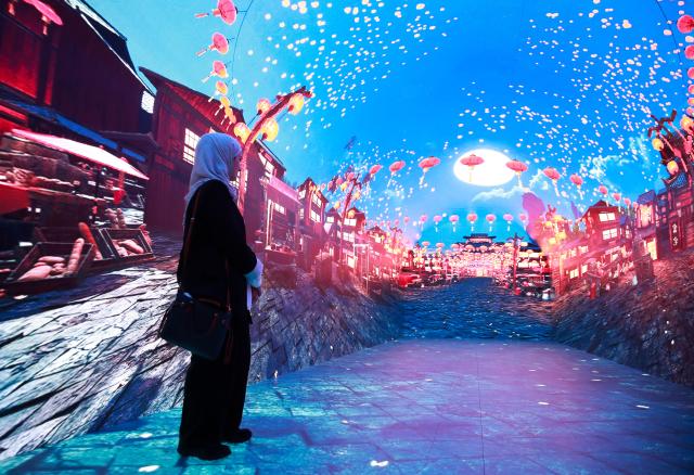 (260210) -- SYDNEY, Feb. 10, 2026 (Xinhua) -- A woman enjoys an immersive digital experience exhibition with Chinese cultural element at DigiPark Sydney in Sydney, Australia, Feb. 10, 2026. The DigiPark Sydney launched an immersive digital experience exhibition on traditional Chinese cultures, which is supported by holographic digital display technology. (Xinhua/Ma Ping)