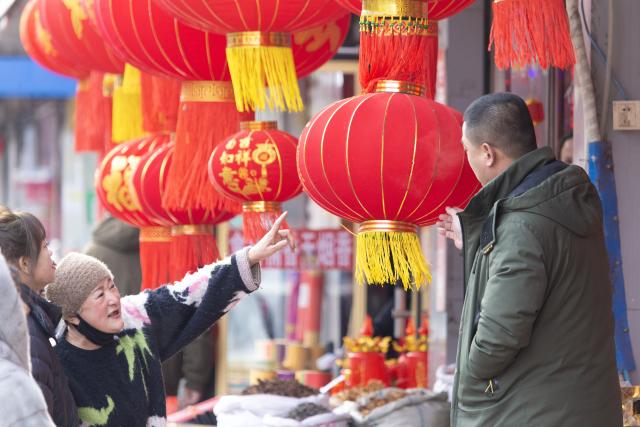 (260210) -- BEIJING, Feb. 10, 2026 (Xinhua) -- People buy decorations for the upcoming Spring Festival at a market in Fujin City, northeast China's Heilongjiang Province, Feb. 10, 2026. Various kinds of activities were held on Tuesday to celebrate the traditional Chinese Xiaonian Festival in northern China, which marks the start of the countdown to the Spring Festival. (Photo by Qu Yubao/Xinhua)