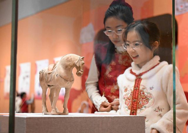(260210) -- BEIJING, Feb. 10, 2026 (Xinhua) -- Visitors view a horse-shaped figurine at Hebei Museum in Shijiazhuang, north China's Hebei Province, Feb. 10, 2026. Various kinds of activities were held on Tuesday to celebrate the traditional Chinese Xiaonian Festival in northern China, which marks the start of the countdown to the Spring Festival. (Photo by Chen Qibao/Xinhua)