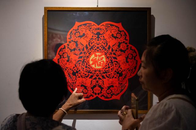 (260210) -- KUALA LUMPUR, Feb. 10, 2026 (Xinhua) -- People appreciate a paper-cutting artwork of the Year of the Horse in Selangor state, Malaysia, Feb. 5, 2026. As the Spring Festival approaches, traditional Chinese art of paper-cutting featuring the Year of the Horse increased the festive atmosphere in Malaysia. (Photo by Chong Voon Chung/Xinhua)