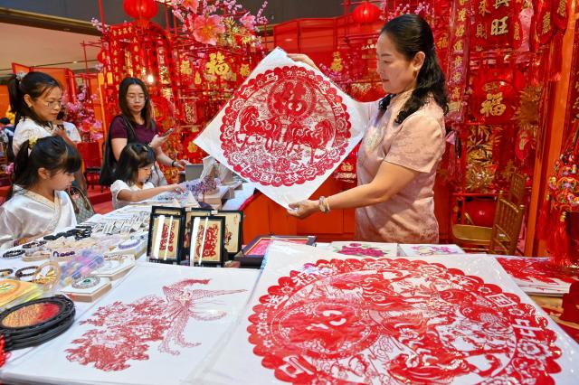(260210) -- KUALA LUMPUR, Feb. 10, 2026 (Xinhua) -- A woman displays a paper-cutting artwork of the Year of the Horse for the upcoming Chinese New Year in Selangor state, Malaysia, Feb. 8, 2026. As the Spring Festival approaches, traditional Chinese art of paper-cutting featuring the Year of the Horse increased the festive atmosphere in Malaysia. (Photo by Chong Voon Chung/Xinhua)