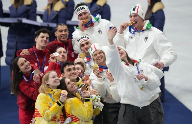 (260210) -- MILAN, Feb. 10, 2026 (Xinhua) -- Gold medalists team Italy (R) take a selfie with silver medalists team Canada and bronze medalists team Belgium (front) during the awarding ceremony for the short track speed skating mixed team relay at the Milan-Cortina 2026 Olympic Winter Games in Milan, Italy, Feb. 10, 2026. (Xinhua/Xue Yuge)