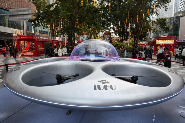 (260210) -- SHENZHEN, Feb. 10, 2026 (Xinhua) -- A flying saucer-shaped electric vertical takeoff and landing (eVTOL) aircraft is pictured at a flower market in Futian District of Shenzhen, south China's Guangdong Province, on Feb. 10, 2026. The 2026 Spring Festival flower market opened in Shenzhen on Tuesday, with major flower markets and convenient flower stores set up in all districts of the city to facilitate citizens' purchase of flowers and new year's goods for the festival. (Xinhua/Liang Xu)