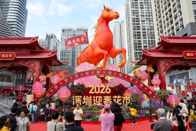 (260210) -- SHENZHEN, Feb. 10, 2026 (Xinhua) -- People take photos at a flower market in Futian District of Shenzhen, south China's Guangdong Province, on Feb. 10, 2026. The 2026 Spring Festival flower market opened in Shenzhen on Tuesday, with major flower markets and convenient flower stores set up in all districts of the city to facilitate citizens' purchase of flowers and new year's goods for the festival. (Xinhua/Liang Xu)