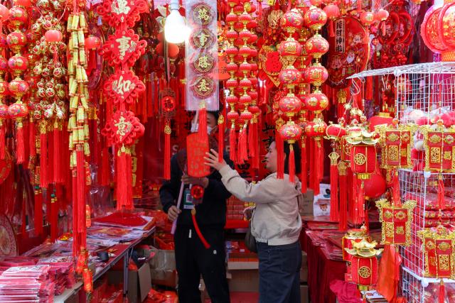 (260210) -- SHENZHEN, Feb. 10, 2026 (Xinhua) -- People buy new year's goods at a flower market in Futian District of Shenzhen, south China's Guangdong Province, on Feb. 10, 2026. The 2026 Spring Festival flower market opened in Shenzhen on Tuesday, with major flower markets and convenient flower stores set up in all districts of the city to facilitate citizens' purchase of flowers and new year's goods for the festival. (Xinhua/Liang Xu)