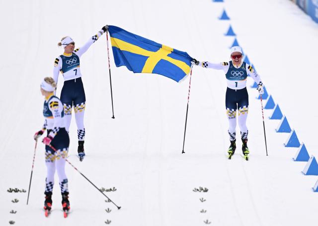 (260210) -- TESERO, Feb. 10, 2026 (Xinhua) -- Gold medalist Linn Svahn (R) of Sweden, silver medalist Jonna Sundling (L) of Sweden and bronze medalist Maja Dahlqvist of Sweden react after the cross-country skiing women's sprint classic final at the Milan-Cortina 2026 Olympic Winter Games in Tesero, Italy, Feb. 10, 2026. (Xinhua/He Canling)