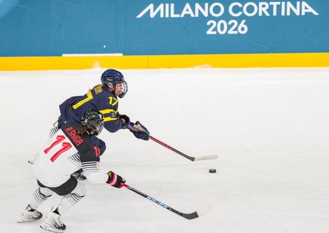 (260210) -- MILAN, Feb. 10, 2026 (Xinhua) -- Sofie Lundin(Top) of Sweden breaks through during the ice hockey women's preliminary round group B match between Sweden and Japan at the Milan-Cortina 2026 Olympic Winter Games in Milan, Italy, Feb. 10, 2026. (Xinhua/Sun Fei)