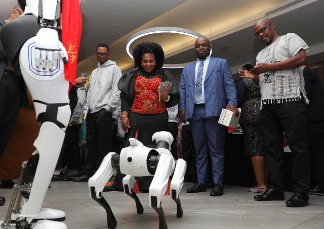 (260210) -- JOHANNESBURG, Feb. 10, 2026 (Xinhua) -- People interact with a robot dog during a reception to celebrate the upcoming Chinese New Year in Johannesburg, South Africa, Feb. 9, 2026. The Chinese Consulate General in Johannesburg hosted a reception Monday to celebrate the upcoming Chinese New Year of Horse, which falls on Feb. 17.
   TO GO WITH "Chinese Consulate General in Johannesburg celebrates upcoming Chinese New Year" (Xinhua/Chen Wei)