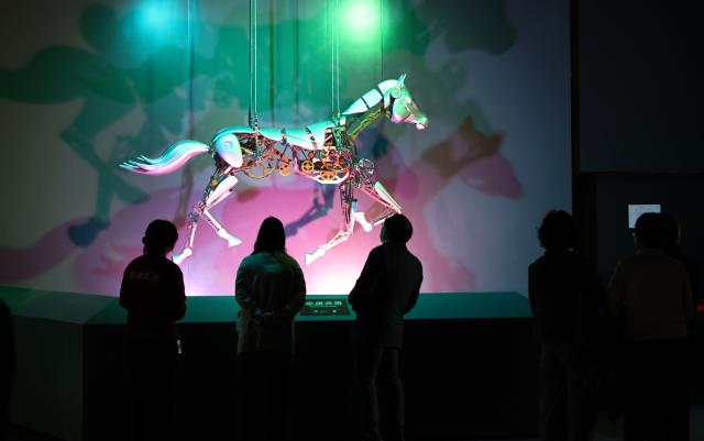 (260210) -- SHANGHAI, Feb. 10, 2026 (Xinhua) -- Visitors view a mechanical horse exhibit during Galloping Wonders: Year of the Horse Science & Culture Exhibition at Shanghai Science & Technology Museum in east China's Shanghai, Feb. 10, 2026. Jointly hosted by Shanghai Science & Technology Museum and the Palace Museum, the exhibition kicked off here on Tuesday. (Xinhua/Fang Zhe)