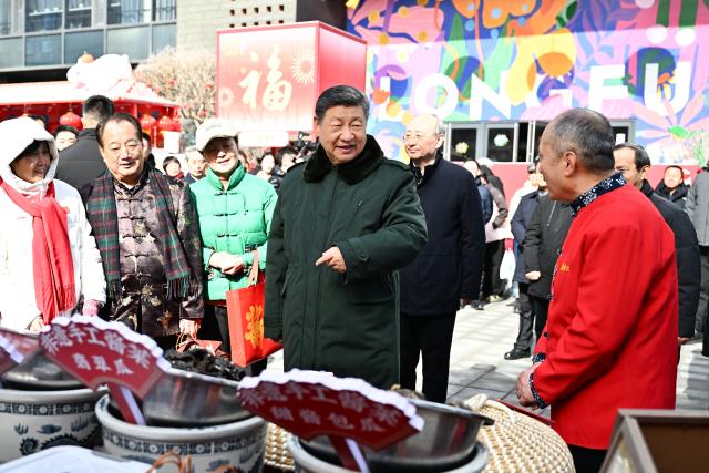 (260210) -- BEIJING, Feb. 10, 2026 (Xinhua) -- Chinese President Xi Jinping, also general secretary of the Communist Party of China Central Committee and chairman of the Central Military Commission, talks with people while visiting a Spring Festival market at the Longfusi commercial area in Dongcheng District of Beijing, capital of China, Feb. 10, 2026. Xi visited primary-level officials and residents in Beijing during a two-day inspection tour from Monday to Tuesday. (Xinhua/Yan Yan)