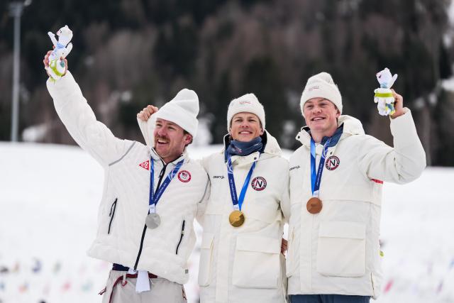 (260210) -- TESERO, Feb. 10, 2026 (Xinhua) -- Gold medalist Johannes Hoesflot Klaebo (C) of Norway, silver medalist Ben Ogden (L) of the United States and bronze medalist Oskar Opstad Vike (R) of Norway pose for photos during the awarding ceremony of the cross-country skiing men's sprint classic at the Milano Cortina 2026 Olympic Winter Games in Tesero, Italy, Feb. 10, 2026. (Xinhua/Peng Ziyang)