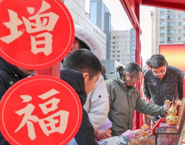 (260210) -- BEIJING, Feb. 10, 2026 (Xinhua) -- People select handicrafts at a Spring Festival market of Longfusi commercial area in Dongcheng District of Beijing, capital of China, on Feb. 10, 2026. As the Spring Festival approaches, the Longfusi commercial area is filled with festive atmosphere, attracting a large number of citizens and tourists to visit here. (Xinhua/Chang Nengjia)