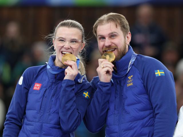 (260210) -- CORTINA D'AMPEZZO, Feb. 10, 2026 (Xinhua) -- Rasmus Wranaa (R) and Isabella Wranaa of Sweden bite their medals during the awarding ceremony of the curling mixed doubles at the Milan-Cortina 2026 Olympic Winter Games in Cortina, Italy, Feb. 10, 2026. (Xinhua/Ding Xu)