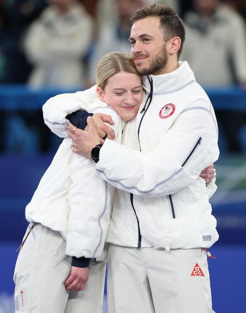 (260210) -- CORTINA D'AMPEZZO, Feb. 10, 2026 (Xinhua) -- Korey Dropkin (R) of the United States hugs his teammate Cory Thiesse during the awarding ceremony of the curling mixed doubles at the Milan-Cortina 2026 Olympic Winter Games in Cortina, Italy, Feb. 10, 2026. (Xinhua/Ding Xu)