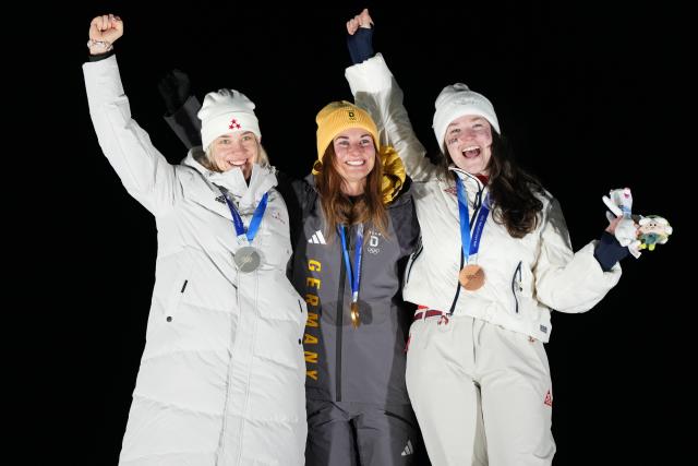 (260210) -- CORTINA D'AMPEZZO, Feb. 10, 2026 (Xinhua) -- Gold medalist Julia Taubitz (C) of Germany, silver medalist Elina Bota (L) of Latvia and Ashley Farquharson of the United States celebrate during the awarding ceremony of the luge women's singles at the Milan-Cortina 2026 Olympic Winter Games in Cortina, Italy, Feb. 10, 2026. (Xinhua/Li Gang)