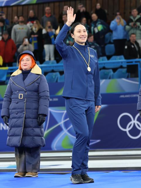 (260210) -- CORTINA D'AMPEZZO, Feb. 10, 2026 (Xinhua) -- International Olympic Committee (IOC) member Zhang Hong (R) waves during the awarding ceremony of the curling mixed doubles at the Milan-Cortina 2026 Olympic Winter Games in Cortina, Italy, Feb. 10, 2026. (Xinhua/Ding Xu)