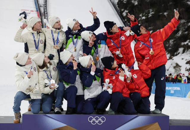 (260210) -- PREDAZZO, Feb. 10, 2026 (Xinhua) -- Gold medalists (C) from team Slovenia, silver medalists (L) from team Norway and bronze medalists from team Japan take a selfie during the awarding ceremony of the ski jumping mixed team match at the Milan-Cortina 2026 Olympic Winter Games in Predazzo, Italy, Feb. 10, 2026. (Xinhua/Huang Wei)