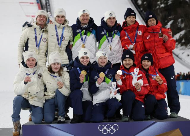(260210) -- PREDAZZO, Feb. 10, 2026 (Xinhua) -- Gold medalists (C) from team Slovenia, silver medalists (L) from team Norway and bronze medalists from team Japan pose for a photo during the awarding ceremony of the ski jumping mixed team match at the Milan-Cortina 2026 Olympic Winter Games in Predazzo, Italy, Feb. 10, 2026. (Xinhua/Huang Wei)