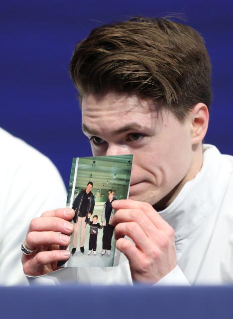 (260210) -- MILAN, Feb. 10, 2026 (Xinhua) -- Maxim Naumov of the United States shows a photo of his parents who were killed in a plane crash last year, after the short program competition of figure skating men single skating at the Milan-Cortina 2026 Olympic Winter Games in Milan, Italy, Feb. 10, 2026. (Xinhua/Li Ming)