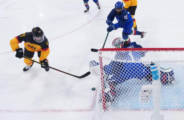(260210) -- MILAN, Feb. 10, 2026 (Xinhua) -- Nicola Hadraschek (1st L) of Germany shoots during the ice hockey women's preliminary round group B match between Germany and Italy of the Milan-Cortina 2026 Olympic Winter Games in Milan, Italy, Feb. 10, 2026. (Wang Kaiyan/Pool via Xinhua)