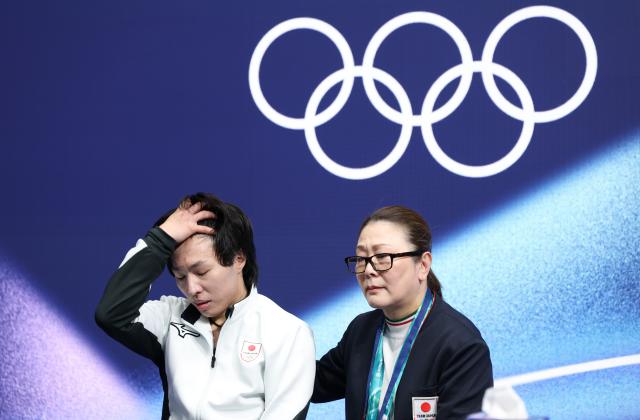 (260211) -- MILAN, Feb. 11, 2026 (Xinhua) -- Miura Kao (L) of Japan looks dejected as he waits for the scores during the short program competition of figure skating men single skating at the Milan-Cortina 2026 Olympic Winter Games in Milan, Italy, Feb. 10, 2026. (Xinhua/Li Ming)