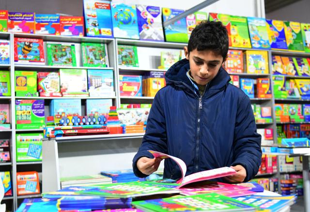 (260211) -- DAMASCUS, Feb. 11, 2026 (Xinhua) -- A boy browses a kids' book at the International Book Fair in Damascus, Syria, Feb. 10, 2026. (Photo by Ammar Safarjalani/Xinhua)