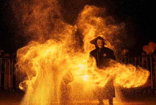 (260211) -- BEIJING, Feb. 11, 2026 (Xinhua) -- An artist performs Huohu (fire pot) at the ancient town of Ciqikou in southwest China's Chongqing Municipality, Feb. 10, 2026. (Xinhua/Chen Cheng)