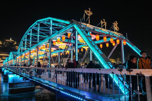 (260211) -- LANZHOU, Feb. 11, 2026 (Xinhua) -- People visit the Zhongshan bridge decorated with lanterns in Lanzhou, northwest China's Gansu Province, Feb. 10, 2026. With the Spring Festival approaching, festive events are held across China to usher in the holiday. (Xinhua/Lang Bingbing)