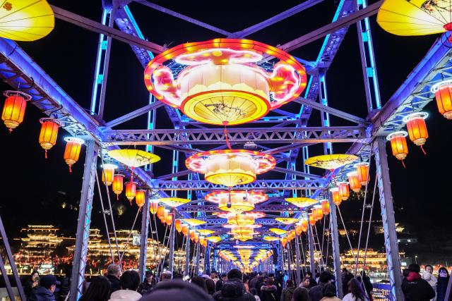 (260211) -- LANZHOU, Feb. 11, 2026 (Xinhua) -- People visit the Zhongshan bridge decorated with lanterns in Lanzhou, northwest China's Gansu Province, Feb. 10, 2026. With the Spring Festival approaching, festive events are held across China to usher in the holiday. (Xinhua/Lang Bingbing)
