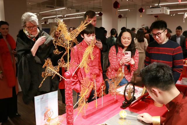 (260211) -- NEW YORK, Feb. 11, 2026 (Xinhua) -- Guests view a Chinese artist making a sugar painting before a Chinese New Year banquet held in Lower Manhattan, New York City, the United States, on Feb. 9, 2026. TO GO WITH "Feature: Chinese New Year banquet in New York celebrates culinary heritage, cross-cultural connections" (Photo by Vivien Liu/Xinhua)