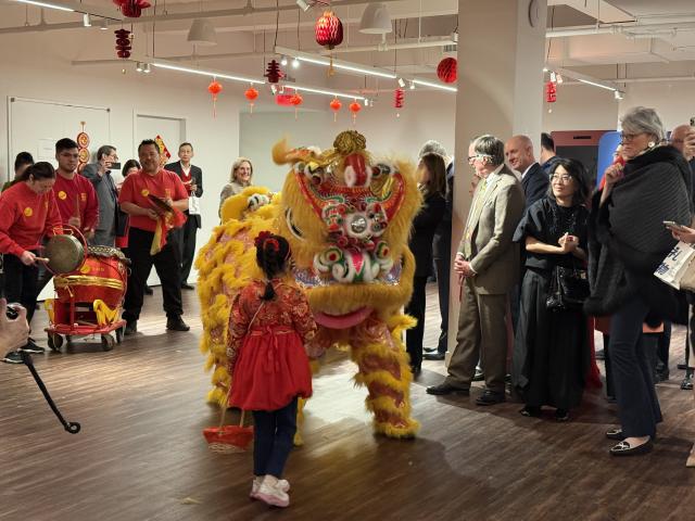 (260211) -- NEW YORK, Feb. 11, 2026 (Xinhua) -- A young girl greets a dancing lion before a Chinese New Year banquet held in Lower Manhattan, New York City, the United States, on Feb. 9, 2026. TO GO WITH "Feature: Chinese New Year banquet in New York celebrates culinary heritage, cross-cultural connections" (Photo by Vivien Liu/Xinhua)