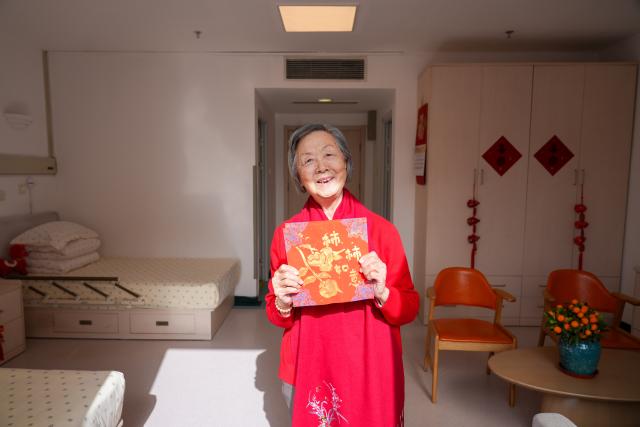 (260211) -- BEIJING, Feb. 11, 2026 (Xinhua) -- Zhao Guiyan, 81, presents a rubbing work she made at a senior care center in Beijing, capital of China, Feb. 10, 2026. TO GO WITH "China Focus: Age-friendly facilities elevate life for China's seniors" (Xinhua/Xie Han)
